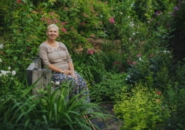 Właścicielka na tle róży Swarzewo znalezionej we wsi Swarzewo znajdującej się pod Puckiem, z prawej strony zdjęcia bieleje róża 'Escimo', za nią intensywnym różem góruje 'General Stefanik' a całość najjaśniejszym różem otula 'Pink Euphoria'