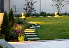 Podwórko dworku z kwietnikiem i trawnikiem z zieloną trawą z marmurowym chodnikiem