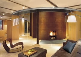 Otwarte na otoczenie pokoje zostały uzupełnione o wydzielone schowki oraz umieszczony centralnie walec z zapleczem sanitarnym. Pierścień korytarza to jednocześnie garderoba. Co ciekawe - od góry dostaje się tu naturalne światło! Wszystkie te przestrzenne zabiegi nie tylko uatrakcyjniają wnętrza, ale i dodają im funkcjonalności