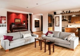 <B>Ania i Wojtek uznali, że wyprowadzka synów jest świetną okazją, by dostosować mieszkanie do własnego stylu życia. Po przebudowie wnętrz mają wreszcie to, o czym od dawna marzyli: rozległą przestrzeń dzienną, w której mogą gościć przyjaciół i eksponować miłe sercu pamiątki.</B> <BR />Duża strefa dzienna powstała po otwarciu kuchni na pokój i włączeniu w  nią sąsiedniego pomieszczenia (dawnej sypialni syna). Zrezygnowano też z drzwi do przedpokoju, co dodatkowo powiększyło przestrzeń. Wygodny wypoczynek zapewniają obszerne sofy i dwa fotele.