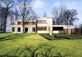 Rozłożysta bryła z wieloma tarasami została wykończona piaskowcem i drewnem