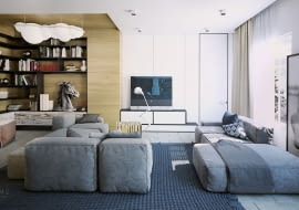 Dwie niskie sofy zachęcają do odpoczynku, a zastosowanie kolorów niebieskiego i szarego w przyjemnych odcieniach połączone z ciepłym drewnem tworzą relaksacyjny nastrój. W części bibliotecznej lampa w kształcie chmury Nemo Nuvola.