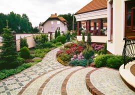 Przykład połączenia materiałów okładzinowych: krawędzie wykończone cegłą klinkierową, stopnice - szorstką, a więc bezpieczną - kostką kamienną, jak na alejkach w ogrodzie.