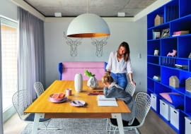 Projekt wnętrza domu opiera się na zabawie kolorami oraz zestawieniu surowych struktur (jak beton czy płyta OSB) z miękkimi tkaninami i gładkimi powierzchniami mebli.