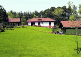 Jeśli inwestorzy dysponują dostatecznie dużą działką, dobrym pomysłem na rozbudowę może być uzupełnienie głównej bryły budynku dodatkowymi zabudowaniami, które przejmą część funkcji domu. W ogrodzie może powstać wiata na samochód, letnia kuchnia, a nawet pokój gościnny w oddzielnym domku. Taka rozbudowa pomoże zagospodarować działkę i nie zdezorganizuje życia domowników