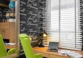 <B>Dla Pani Kasi, która pracuje w domu przy biurku ustawionym pod oknem, przy wyborze dekoracji okiennej bardzo ważna była możliwość swobodnego regulowania dopływu światła do gabinetu. Te oczekiwania najlepiej spełniały drewniane żaluzje.</B> <BR />Żaluzje zrobiono na wymiar z szerokich listewek z rozbielonego drewna. Jej prosta forma nie konkuruje z wyrazistą tapetą w graficzny wzór, którą oklejono ściany gabinetu.