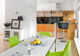 <B>Ledwo przyniosłam kilka rzeczy i zaplanowałam parapetówkę, gdy okazało się, że muszę lecieć do USA. Zamiast wprowadzić się do wymarzonego domu, zaczęłam szukać najemców - wspomina Adrianna. Montse i Josep, zauroczeniu przestronnymi, przesyconymi światłem wnętrzami, nie wahali się ani chwili. Szybko je gustownie urządzili i pokochali tak jak ja.</B> <BR />Niemal cały parter domu to otwarta przestrzeń dzienna. Kuchnię przesłania wąska ścianka, za którą  ukryto sprzęt AGD. Zabudowa w kształcie litery L, z frontami fornirowanymi drewnem czereśni, zapewnia wygodne miejsce do pracy i dużo pojemnych schowków. Przy barku na końcu ciągu roboczego domownicy najczęściej jadają śniadanie.