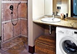 Wnętrza. Kamienny blat z umywalką służy również jako półka na kosmetyki. Inne rzeczy są trzymane w kuferku stojącym obok pralki. Wnętrze oświetla sufitowa lampa z trzema ruchomymi reflektorkami i kinkiety zamontowane na lustrze.