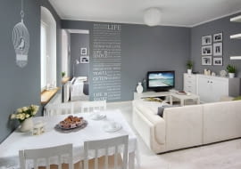 Pan Tomasz żartuje, że w czasie urządzania tego mieszkania znajdującego się w prawie stuletniej kamienicy powinni byli dostać zniżkę na szarą i białą farbę. Na ten pierwszy kolor pani Marta pomalowała bowiem niemal wszystkie ściany, a na drugi - meble i dodatki. <BR /> MIESZKANIE. Stół i krzesła, komody oraz półeczki zostały przemalowane. Wśród białych sprzętów musiała stanąć biała kanapa. Ażurowy obrus przykrywający stół był w poprzednim życiu firaną. Gospodyni znalazła ją w piwnicy babci. Nad stołem urocza naklejka - ptaszek w klatce.