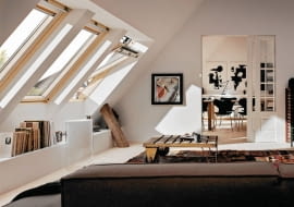 <B> Wnętrza ze skosami mają wiele uroku, często jednak brak nam pomysłu, jak praktycznie zagospodarować kłopotliwe zakamarki pod pochyłym dachem, zwykle z oknem dachowym. Poznajcie nasze propozycje. </B><BR /> Specjalista Justyna Burdow-Gołoś Architekt Wnętrz radzi: <BR /> Aby jak najlepiej wykorzystać przestrzeń pod skosami, warto pamiętać o kilku zasadach. Okna połaciowe dobrze oświetlają wnętrze, gdyż światło wpadające pod kątem i z góry jest bardzo jasne. Standardowa wysokość takich okien wynosi od 80 do 120 centymetrów, ważniejsza jednak jest wysokość, na której są umieszczone. Jeśli będą zbyt nisko, wpuszczą mniej światła, a do tych zamontowanych zbyt wysoko będziemy mieć trudny dostęp, co ma znaczenie przy ich otwieraniu i myciu. Elementy konstrukcyjne (belki, słupy, podciągi) nie powinny być przestawiane ani likwidowane bez uprzedniej konsultacji z fachowcem. Pamiętajmy o tym na etapie planowania przestrzeni. Zamiast zmieniać położenie tych elementów, lepiej wykorzystać je w aranżacji - na przykład obudować zawsze przydatnymi półkami czy szafkami. Skosy sięgające podłogi warto zabudować niską ścianką, przy której łatwiej będzie ustawić meble. W takiej przegrodzie można również zamontować drzwiczki - wtedy przestrzeń za nią stanie się dodatkowym schowkiem. <BR /> ARANŻACJA WNĘTRZ. Podręczna biblioteczka. Wzdłuż ściany z oknami połaciowymi zaprojektowano półkę. Stoją na niej nie tylko ozdobne drobiazgi, ale również książki. Zabudowę zrobiono z płyty gipsowo-kartonowej. Belkę konstrukcyjną pozostawiono odkrytą - taka dekoracja bardzo pasuje do tego wnętrza.