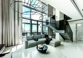 Salon - jasne, przestronne wnętrze, a w nim ciemne akcenty, takie jak czarne schody. Ogromne okna z pięknym widokiem na niebo. Specjalnie zaprojektowane lampy - pierścienie są bardzo delikatne, by nie przysłaniać żadnego jego fragmentu.