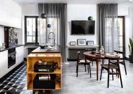 W części kuchennej blat granitowy, bliżej drzwi lekkie półki z?drewnianym blatem.