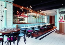 Wieloosobowa tapicerowana kanapa pod ścianą luster nawiązuje do ławek wzdłuż sopockiego molo.