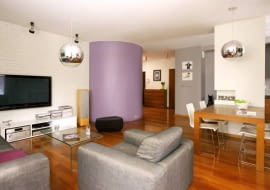 <B>Wielu projektantów uważa, że w każdym mieszkaniu powinno być jakieś oryginalne rozwiązanie, mebel lub urządzenie - coś, co będzie przyciągać uwagę i kojarzyć się z wnętrzem. W tym przypadku jest to garderoba o ciekawej formie walca.</B> <BR />Ściana, na której zawieszono telewizor, to pomalowana na biało cegła. Taką samą gospodarze mieli w poprzednim mieszkaniu, poprosili więc projektantkę, by w nowym uwzględniła takie rozwiązanie.