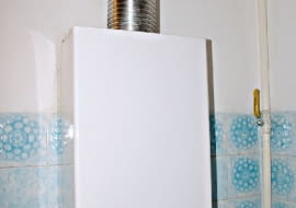 Piecyk gazowy podłączony do komina poprzez rurę wykonaną ze stali kwasoodpornej.