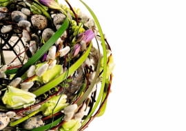 WIENIEC Z BAZAMI I KWIATAMI Jego podstawę stanowi kolista konstrukcja z drutu, pomiędzy który wpleciono bazie, tulipany, frezje, trzcinę, trawę i doklejono sztuczne jajka.