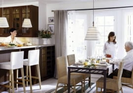 Szereg stojących szafek kuchennych w wyraźny sposób oddziela strefę kuchni od salonu