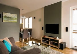 Niewielkie mieszkanie pani Renaty miało być kobiece, ale nie przesłodzone; nowoczesne, ale nie chłodne; przytulne, ale bez nadmiaru dodatków i dekoracji. Zdaniem projektantki wnętrze przypomina teraz puzderko - pełne uroku, choć bez biżuterii. Nie oszałamia ozdobami, ale nie pozostawia też obojętnym. <BR /> MIESZKANIE. Stonowane barwy: zgaszona zieleń, szarości, biel współgrają z jasnym odcieniem drewna. Tę spokojną kolorystykę ożywiają nieliczne turkusowe akcenty. Za panelem z telewizorem zamontowano lampki ledowe, których światło tworzy wieczorem miły nastrój.