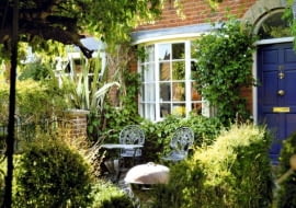 W tym maleńkim ogródku, gdzie mieszczą się zaledwie dwa krzesła, nastrój tworzą pnącza