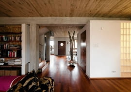 Betonowe sufity, odsłonięte słupy konstrukcyjne i ceglane ściany zmieniły mieszkanie w tradycyjnym szeregowcu w nowoczesne, przestronne wnętrza nawiązujące do stylu loftów. A jednak ten dom jest pozbawiony charakterystycznej dla nich surowości. Pan Robert, właściciel, a zarazem projektant, ocieplił go drewnem, tkaninami i obrazami własnego autorstwa. <BR /> DOM. Łazienka została urządzona w kubiku, na którego suficie chętnie wylegują się domowe koty. Jedną ze ścian częściowo przeszklono luksferami, dzięki czemu do pomieszczenia wpada naturalne światło.