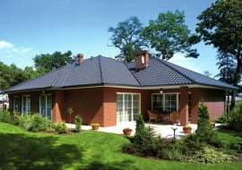 Taras ziemny wykonany z jasnych płyt kamiennych - kontrastuje z kolorem elewacji domu