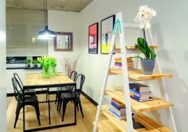 Kuchnia z jadalnią powstała z dwóch pomieszczeń – starej, wąskiej kuchni i sąsiadującej z nią niewielkiej sypialni. Teraz można wygodnie usiąść w niej przy dużym stole. W pomieszczeniu udało się zmieścić dodatkową szafę gospodarczą z ukrytą w niej pralką.