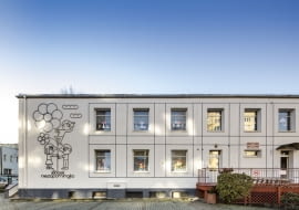 Odnowiony żłobek w Gdyni. Oszczędna w formie fasada, a na niej ilustracja metaloplastyczna zdradzająca funkcje budynku