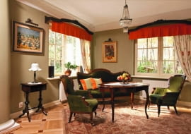 Architektura domu, nawiązująca do dworku polskiego, pozostaje w harmonii z wystrojem wnętrza. Na każdym kroku widać tu dbałość o szczegóły. Urodę starych mebli podkreślają dobrane ze smakiem stylowe dodatki i tkaniny. Nic dziwnego: gospodarze zgodnie twierdzą, że dom jest oczkiem w głowie całej rodziny. <BR /> DOM. Oliwkowy odcień farby na ściany został dopasowany do obicia foteli.