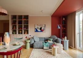 W tym mieszkaniu kolor nie jest dodatkiem, lecz pełnoprawnym bohaterem, który kreuje przestrzeń pełną emocji. Na zdjęciu niebieska sofa to model marki Optisofa, a stojąca niebieska lampa producenta Aldex. Na niebieskim stoliku ze sklepu Jotex wyeksponowano wazon Nana Malwiny Konopackiej. Honorowe miejsce nad sofą zajmuje obraz Agnieszki Pietrzykowskiej.