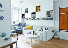 GDZIEKOLWIEK SPOJRZEĆ - SCHOWKI. Gospodarze mówią, że mają ich 'na zapas', z czego bardzo się cieszą, bo w mieszkaniu wreszcie zapanował porządek. Ścianę nad kanapą zajęła zrobiona na wymiar zabudowa z zamykanymi szafkami i otwartymi półkami. Na ścianie z prawej strony - jedna z części 'tryptyku parawanowego'.