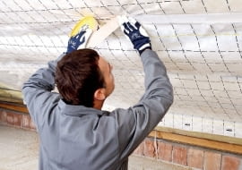 Układanie folii paroizolacyjnej - poszczególne jej pasy szczelnie łączy się specjalną taśmą