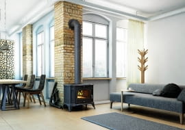 Piec ustawiony w centralnej części salonu, który jest otwarty na pozostałą część domu, w efekcie ciepło rozchodzi się do pomieszczeń znajdujących się w pobliżu kozy