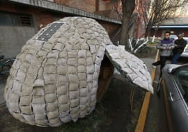 Visitors take photos of an egg-shaped mobile house near its owner Dai Haifei's office building in Beijing December 3, 2010. Dai, who is from central China's Hunan province and cannot afford Beijing's high rental prices, has been living in the house which costs about 6427 yuan ($965). The house is made of bamboo strips, steel bars, heat prevention and waterproof materials, sacks filled with fermented wood chips and grass seeds, as well as one solar-cell panel, local media reported. REUTERS/Petar Kujundzic (CHINA - Tags: BUSINESS SOCIETY)