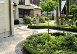 B| Aranżacja ogrodu. Od frontowej strony budynku rosną głównie różaneczniki i bukszpany. Obwódki wprowadzają ład i harmonię