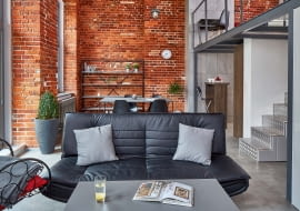 Zwykłe grzejniki płytowe jeszcze na etapie budowy wymieniono na stylizowane żeberkowe, które lepiej wpisują się w klimat pofabrycznego wnętrza.