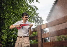 Drewniane ogrodzenie najszybciej i najdokładniej oczyści mocny strumień wody z myjki ciśnieniowej.