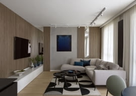 Honorowe miejsce w salonie zajmuje obraz Andrzeja Jana Batora. Granatowe akcenty kolorystyczne na tle bieli, szarości i ciepłej barwy drewna pojawiają się niemal w każdym pomieszczeniu mieszkania.