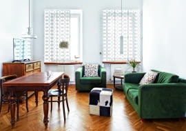 WIĘKSZOŚĆ MEBLI to odzyskane perełki sprzed lat. Eklektyczny dębowy stół z lat 30., krzesła, fotel i rozkładaną kanapę właścicielka kupiła na olx.pl. Stolik kawowy (pod oknem) znalazła na strychu rodzinnego domu, komodę sprezentowali jej przyjaciele.