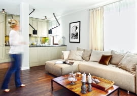 MEBLE KUCHENNE z frontami z lakierowanej płyty MDF zrobiono na zamówienie według projektu architektek. Ponieważ kuchnia jest całkowicie otwarta na pokój dzienny, gospodarze nie chcieli eksponować sprzętów AGD. Dlatego wybrali lodówkę do zabudowy i okap podszafkowy. Nie ma też otwartych półek ani ażurowych witryn - wszystko jest schowane w szafkach. Słup to pozostałość po wyburzonej ścianie. Razem z półwyspem symbolicznie oddziela kuchnię od pokoju dziennego.