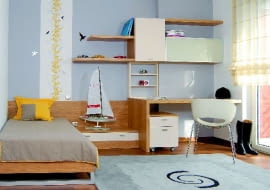 W niewielkim uczniowskim pokoju dobrze sprawdzają się meble o neutralnej kolorystyce - wyrazu nada im osobisty dobytek lokatora