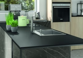 Blat kuchenny z laminatu kompaktowego idealnie wygląda na półwyspie zakończonym stołem