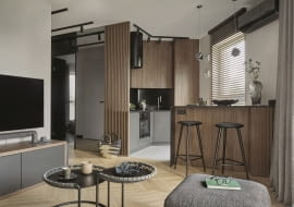 Kuchnia w kolorach i materiałach powtarzających się w aranżacji salonu tworzy spójną z przestrzenią dzienną, wspólną stylistycznie strefę.