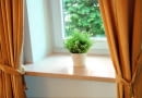 Marmurowy parapet o prostej formie zamontowany we wnęce okiennej