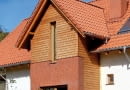 Przed zamontowaniem desek oblicówki, na styku elewacji klinkierowej i drewnianej należy zamontować listwę okapową, chroniącą przed zaciekaniem wody pod ocieplenie ze styropianu - może to być okapnik z blachy powlekanej lub pasek papy wywinięty na dekoracyjną deskę okapową.