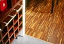 Między parkietem a płytkami ceramicznymi ułożono tzw. listwę dylatacyjną. Zakrywa ona szczelinę - niezbędną w tym miejscu, by drewno mogło 'pracować'. Projekt wnętrza: Radosław Guzowski