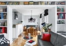 CO ZA PERSPEKTYWA! Po połączeniu dwóch mieszkań powstała przestronna strefa dzienna. Szerokie przejście z salonu do jadalni obudowano płytami gipsowo-kartonowymi, tak by powstały półki na książki oraz miejsce do pracy (jedna z półek wystaje, można na niej wygodnie położyć laptop).
