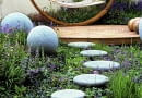 Modern outdoor room has unifying theme of circles and spheres.Concrete balls and stones lead to deck and hammock. Blue ajuga, nepeta and geranium SLOWA KLUCZOWE: Designer Garten Hof Holz H ngematte Kreis Kreise Pflanze Stein Storchschnabel Storchschn bel Trittsteine Wege ausspannen bl´hend enspannen entspannend entspannt erholend friedlich friedvoll geschwungen kreisf^rmig krumm modern relaxed relaxen ruhen zeitgen^ssisch Nicola Stocken Tomkins quadratisch