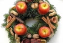 Ozdoby adwentowe. Wieniec ze świecami-jabłkami, laskami cynamonu, orzechami i drobnymi dekoracjami ceramicznymi
