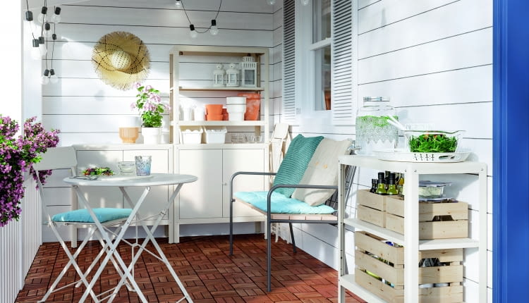 Drewniane skrzynki, dużo kwiatów i doniczki, a nawet słomiany kapelusz jako element dekoracji tworzą sielski klimat.