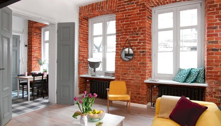 W CZASIE REMONTU odsłonięto starą cegłę - i piękne łuki nad oknami. Żeliwne kaloryfery z odzysku (w sąsiedniej kamienicy robiono remont) pomalowano na czarno. Na podłodze w pokoju ułożono panele imitujące dąb (firmy Kronospan). Ale przedtem posadzka w całym mieszkaniu została dodatkowo zaizolowana, docieplona i pokryta nową wylewką.